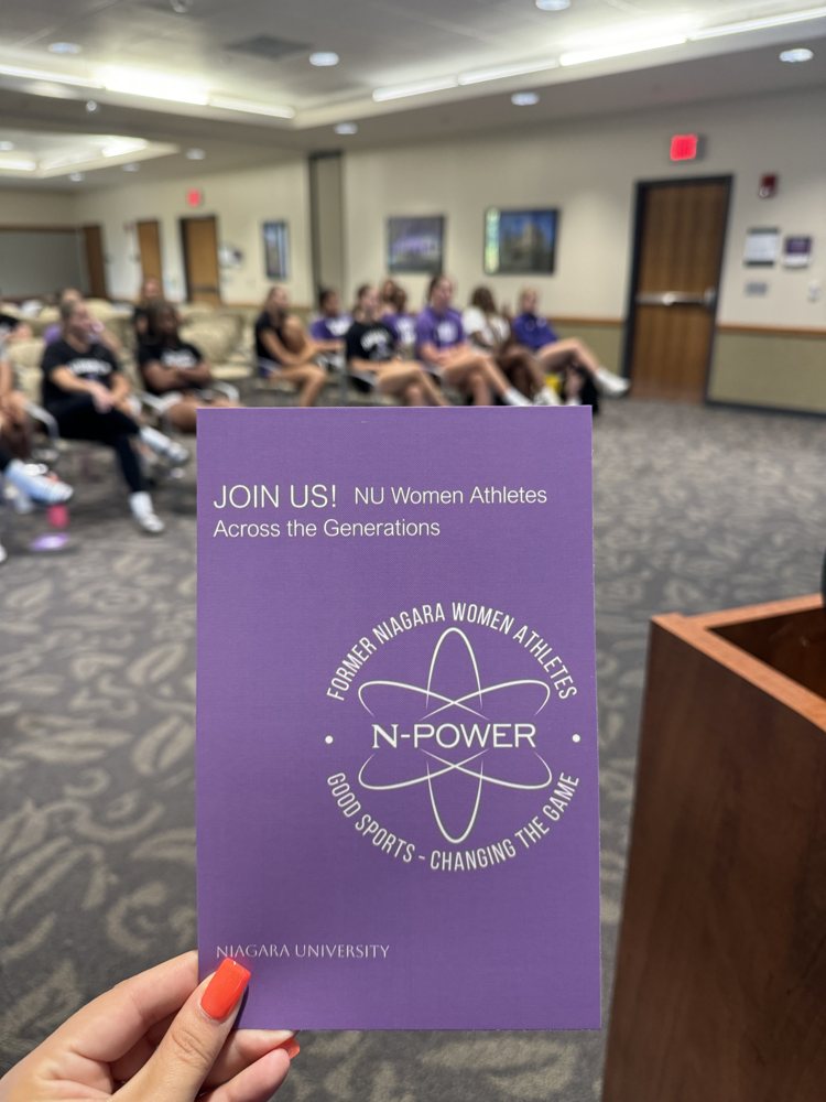 An N-Power invitation brochure held in front of an audience at a presentation