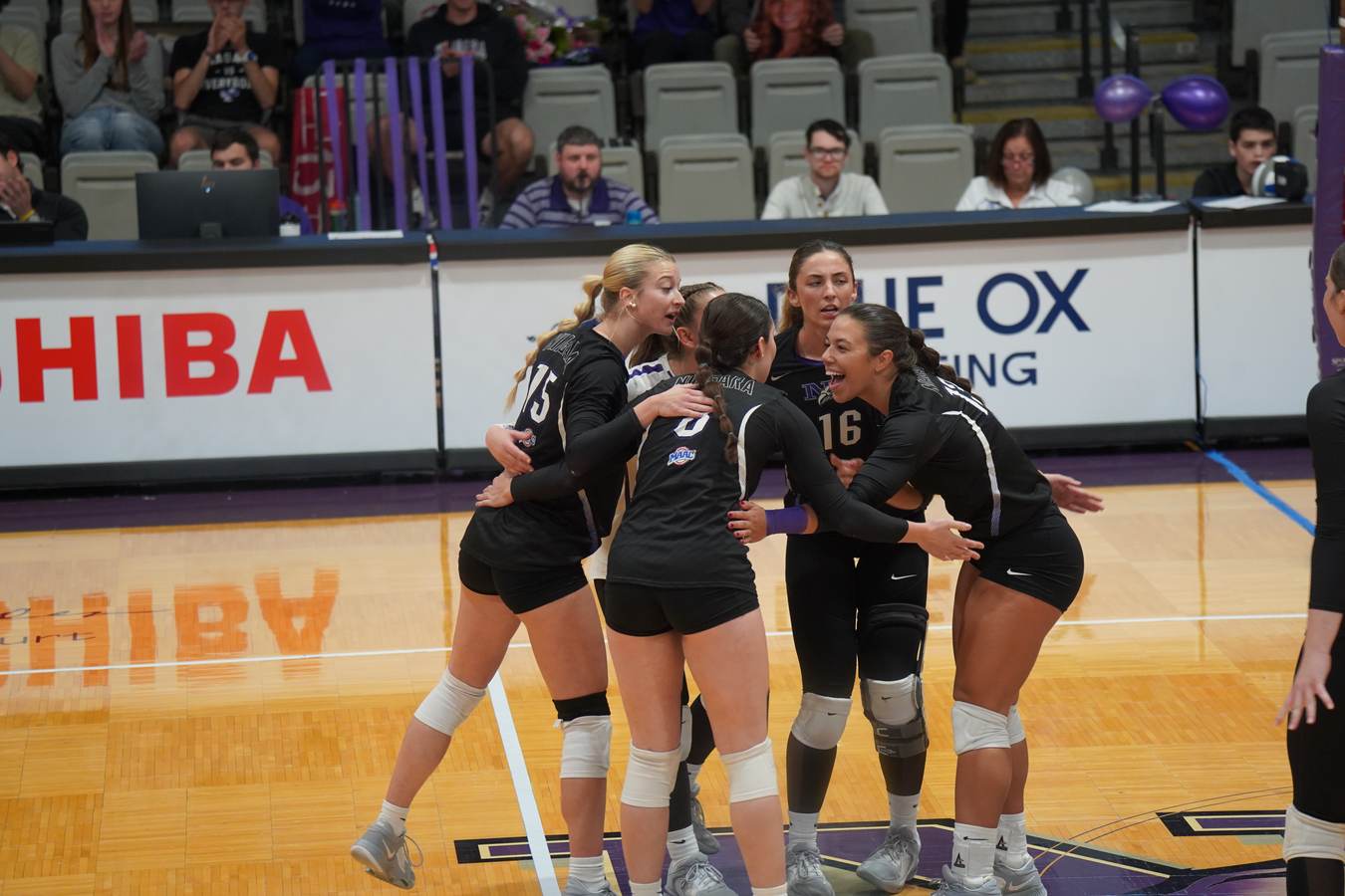 Niagara women’s volleyball players gathering together on the court