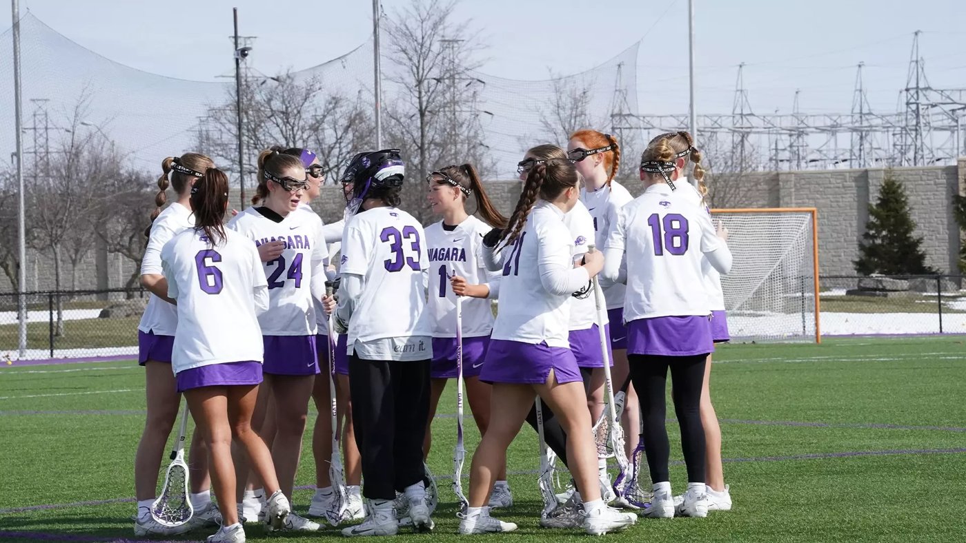 Niagara women’s lacrosse players celebrating together on the field